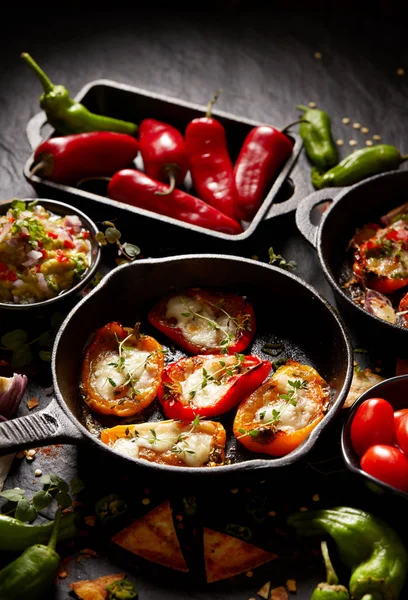 Pimientos dulces a la parrilla poppers rellenos de queso y hierbas, mezcla de deliciosos aperitivos sobre un fondo negro — Foto de Stock