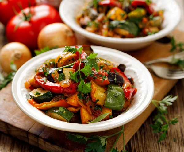 Ratatouille, guiso de verduras hecho de calabacín, berenjenas, pimientos, cebollas, ajo y tomates con hierbas aromáticas. Comida tradicional francesa — Foto de Stock