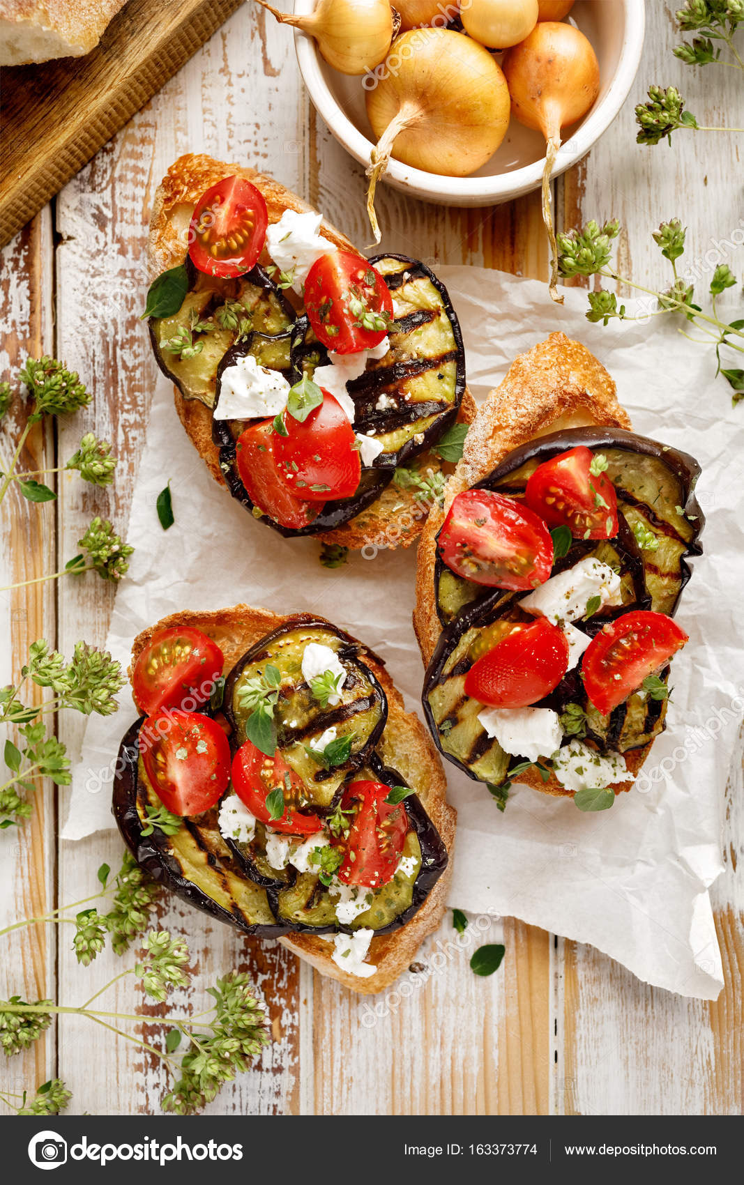 Bruschetta with grilled eggplant, cherry tomatoes, feta cheese, capers