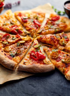 Jalapeno pizza domates ve karanlık bir arka plan üzerinde otlar
