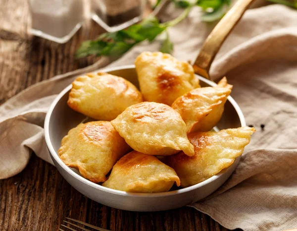 Lor peynir ve besleyici ve lezzetli vejetaryen yemek, ahşap rustik masada bir tavada patates dolma köfte pişmiş geleneksel Polonya yemekleri