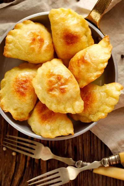 Albóndigas al horno rellenas de queso cuajada y patatas en una sartén sobre mesa rústica de madera, comida vegetariana nutritiva y deliciosa, plato tradicional polaco, vista superior —  Fotos de Stock