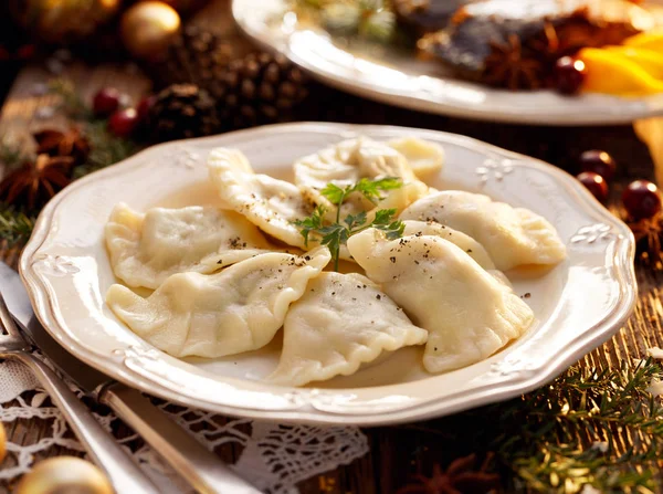 Pierogi z kapusta i grzybami na białym talerzu, znajdujące się na drewnianym stole Christmas. Tradycyjne danie Wigilię Bożego Narodzenia w Polsce — Zdjęcie stockowe