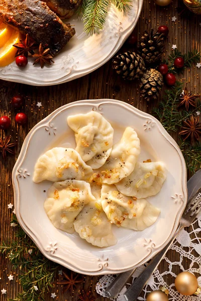 Pierogi z kapusta i grzybami na białym talerzu, znajdujące się na drewnianym stole Christmas. Tradycyjne danie Wigilię Bożego Narodzenia w Polsce — Zdjęcie stockowe