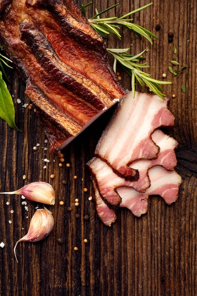 Geräucherter Speck Auf Einem Rustikalen Holztisch Mit Frischen Aromatischen Kräutern — Stockfoto