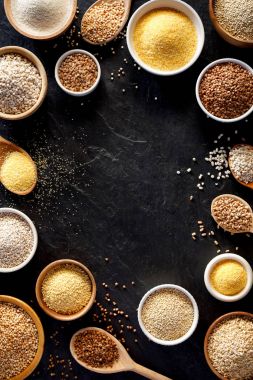 Çeşitli kabuğu çıkarılmış tane, hububat. Kabuğu çıkarılmış tane kase ve bir kaşık siyah bir arka plan, üstten görünüm farklı türleri. Sağlıklı beslenme gıda