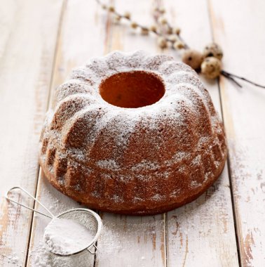 Paskalya Maya kek ahşap beyaz masa üzerine pudra şekeri serpilir. Geleneksel Lehçe paskalya tatlısı