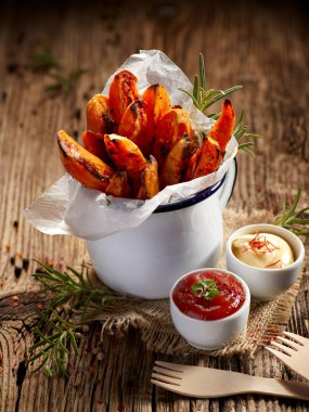 Tecrübeli otlar ve deniz tuzu emaye kupa üzerinde ahşap bir masa, lezzetli ve sağlıklı vejetaryen snack tatlı patates kızartması