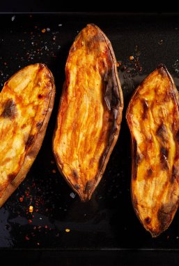 Siyah arka planda baharatlı fırında patlıcan.
