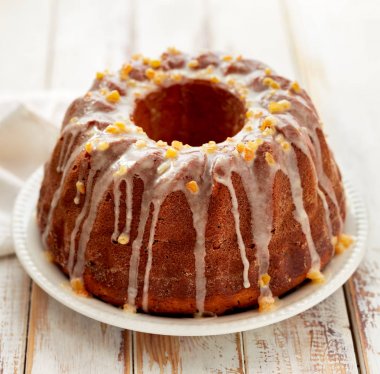 Ahşap bir masa üzerinde beyaz bir tabakta Paskalya Maya kek. Kuru üzüm ve şekerlenmiş portakal kabuğu buzlanma ile geleneksel Paskalya kek