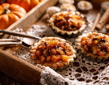 Küçük elmalı turtalar, aromatik tarçınlı ev yapımı elmalı turtalar, kuru üzümler, fındık ve bal, yakın plan. Nefis ev yapımı tatlı.