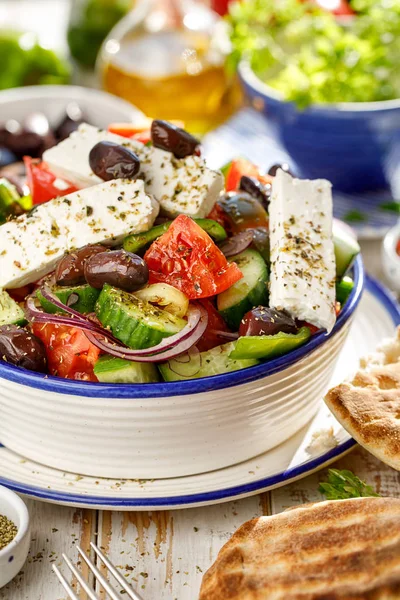 Greek salad. Traditional Greek salad consisting of fresh vegetables such as tomatoes, cucumbers, peppers, onions, oregano and olive oil. A delicious and healthy vegetarian, mediterranean dish