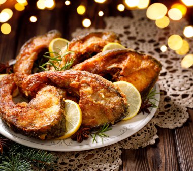 Noel sazanı, bayram masasında seramik tabakta sazan balığı dilimleri, yakın çekim. Geleneksel Noel arifesi yemeği. Polonya Noel 'i