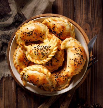Hamur tatlısı, ev yapımı hamur köftesi (pierogi), ahşap bir kırsal masada seramik bir kasede mantar doldurma, üst manzara. Vejetaryen yemeği.