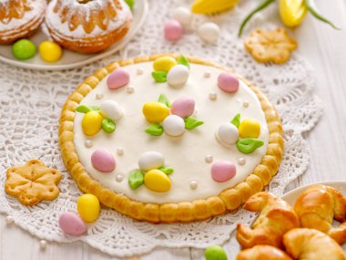 Mazurek pastası, geleneksel Polonya paskalya pastası beyaz çikolata kremalı kısa hamurlu pasta, marzipan yumurtaları ve şeker incileriyle süslenmiş, yakın plan. Tatlı tatlı