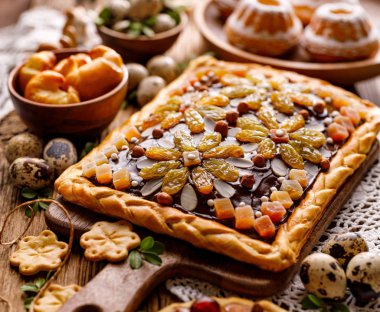 Mazurek pastası, geleneksel Polonya paskalya pastası. Kısa hamurlu pasta, çikolatalı krema, şekerli meyve, fındık ve badem, yakın plan. Çok tatlı, Paskalya ziyafeti.