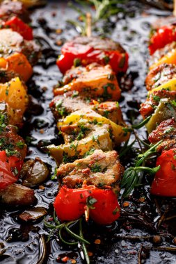 Izgara domuz şişi ve dolmalık biber ve siyah arka planda aromatik otlar ve baharatlar, yakın plan. Barbekü, ızgara, bbq