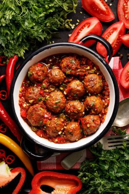Domates soslu köfte ve diş minesi kabına aromatik otlar.