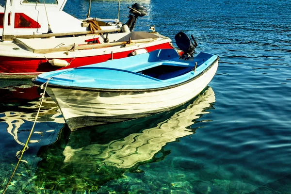 Pequeno barco de pesca refletido na água clara do mar Mediterrâneo — Fotografia de Stock