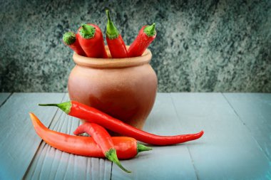 biber biber seramik tencerede ve ahşap tezgah üzerinde