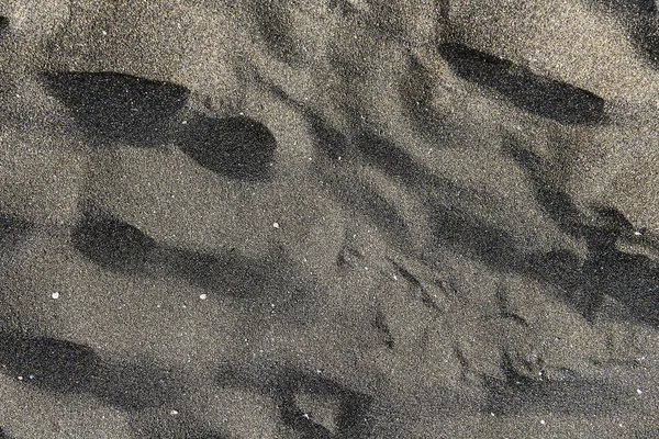 Fotspår i svarta vulkaniska sanden av spanska Teneriffa — Stockfoto