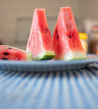 Düz bir tabakta karpuz dilimleri. Tazelik ve plajda yaz mevsimi kavramı. Mutfak arka planı olarak kullanışlı.