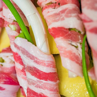 Çiğ taze soğan ve rulo pastırma. Tipik Sicilya sokak yemeği olan 'Cipollata' ızgarada kızartılmış ve yanında kızarmış patates. Kare görünüm.