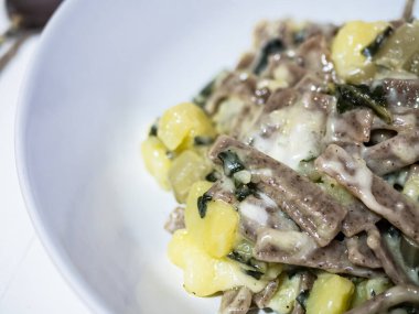 Sofrada beyaz bir tabakta leziz ve tipik İtalyan yemeği Pizzoccheri 'nin yakın çekimi. Valtellina, Lombardy, İtalya 'dan tipik bir yemek. Yatay görünüm.