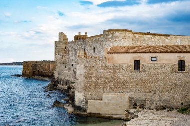 Ortigia Syracuse 'daki deniz ve gökyüzünün önündeki Maniace kalesinin güzel manzarası. Yatay görünüm