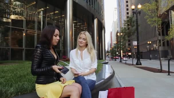 Dwie piękne dziewczyny siedzi w centrum biznesowym po dobre zakupy i mówić — Wideo stockowe