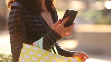 Esmer genç kız alışveriş ve telefonda çağrı ile oturuyor. Aktif bir şey diğer tarafa diyor.