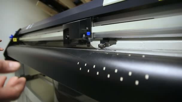 Máquina que corta la película para pegar. Servicio de empleado toma plotter cortado en película — Vídeo de stock