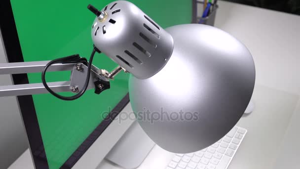 Bordslampa på bakgrunden av datorn på en grön bakgrund — Stockvideo