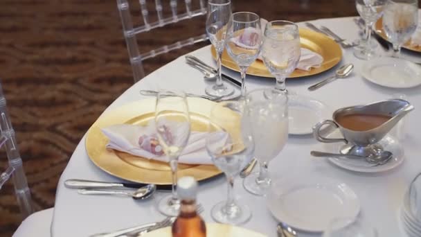 Vasos de cristal con platos naranjas en una mesa de bodas — Vídeos de Stock