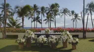 Düğün, yeni evliler tablo yakınındaki beyaz çiçekler önünde palmiye ağaçlarının resort Ziyafet hyatt, maui, hawaii