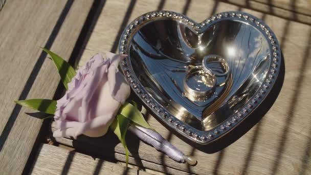 Обручальные кольца в сосуде в виде сердца и прекрасной розы, Мауи, Гавайи — стоковое видео