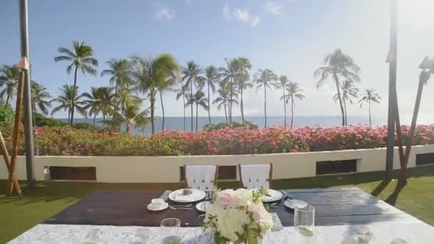 Hochzeitstisch für Brautpaare vor dem Hintergrund roter Blumen und Palmen auf dem Resort hyatt, maui, hawaii — Stockvideo