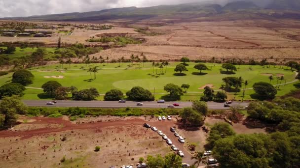 Plano aéreo de paisajes maravillosos de terreno volcánico hermosa naturaleza, varios coches en el fondo de las montañas mauna loa con volcán subaéreo activo en la isla maui, hawaii — Vídeo de stock