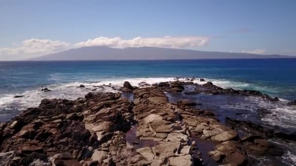Wateren van blauwe oceaan spetters tegen de stenen in de zonnige dag op maui, hawaii — Stockvideo