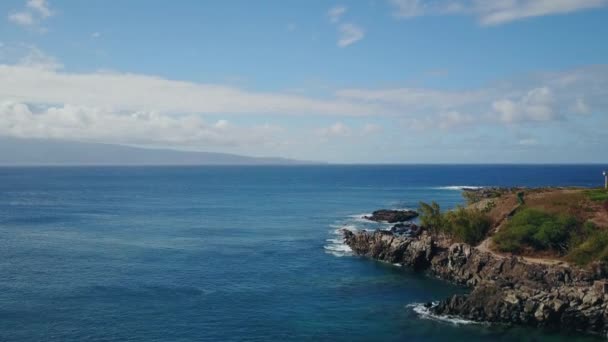 eaux bleues de l'océan Pacifique et le rivage rocheux sous le ciel bleu avec des nuages sur l'île maui, hawaii 