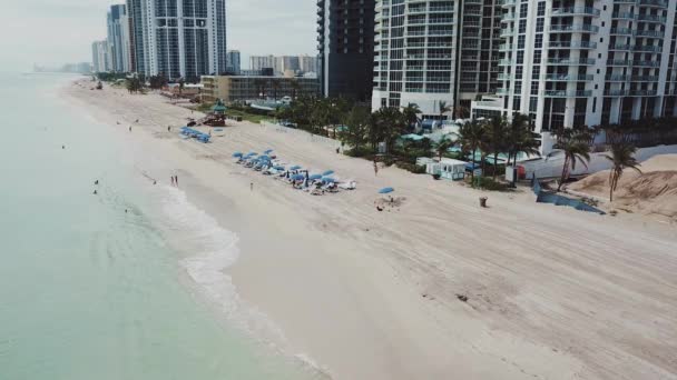 Panorama aéreo de la costa del océano atlántico con turistas bajo sombrillas cerca de los hoteles miami en la playa de las islas soleadas — Vídeos de Stock