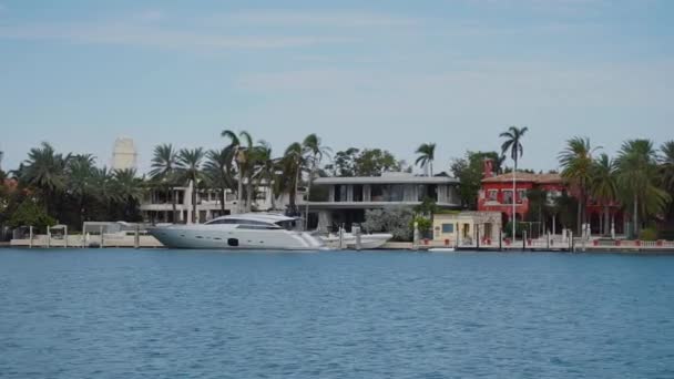 Barco elegante en el terreno de la panadería de aguas azules y hermosas mansiones en la playa de las islas soleadas, miami — Vídeo de stock