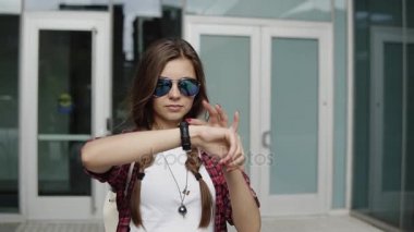 genç ve güzel kadın şık güneş gözlüğü ve ofis girişine yakın onu izlemek zamanında kontrol bir kafes içinde kırmızı gömlek