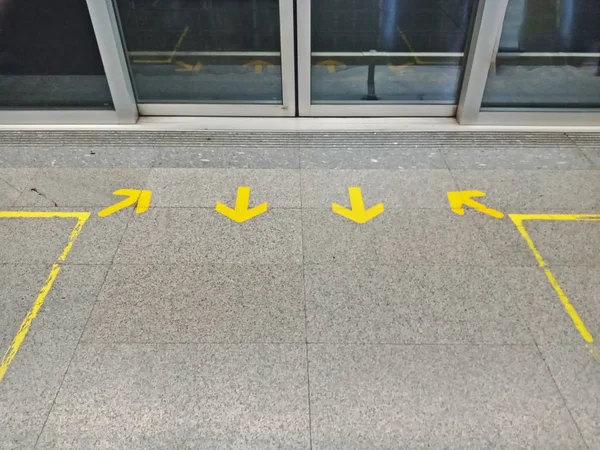 In and Out arrow sign for queue at train station