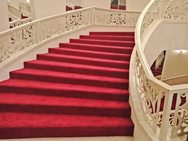 Interior casa com escada curva e tapete vermelho — Fotografia de Stock