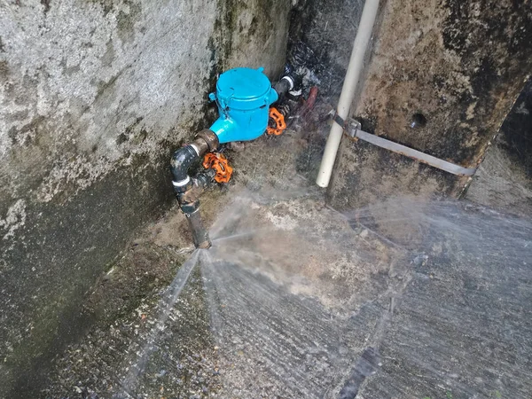 Сломанная водопроводная труба на бетонном полу — стоковое фото