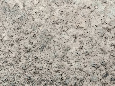 Arka planda bir sürü bok deliği olan gri kum