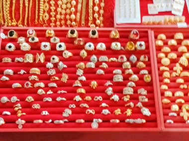 Kırmızı arka planda bulanık mücevherler ve altın yüzük