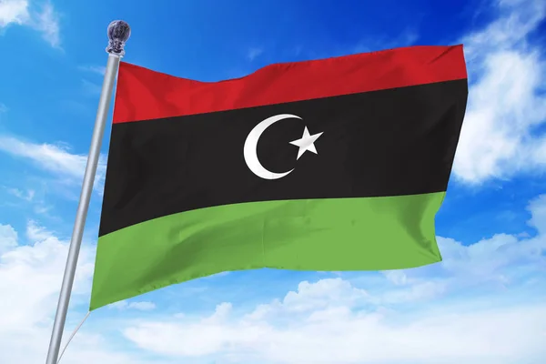 澄んだ青い空に対して開発を行う新しいリビアの国旗 — ストック写真