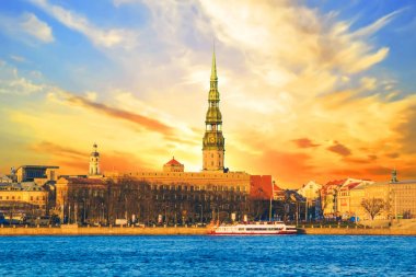 St. Peter Kilisesi bir günbatımı üzerinde Riga, Letonya Daugava Nehri kıyısında güzel görünümü